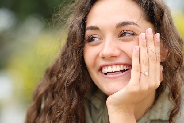 Happy woman showing her healthy teeth after general dental treatment in Norton Shores, MI